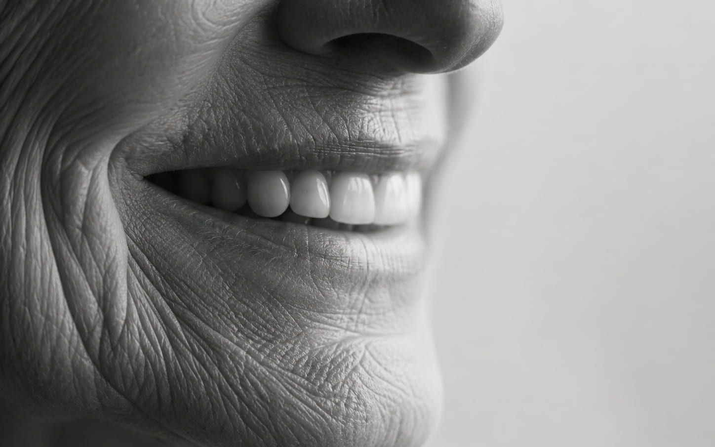 Close-up black and white portrait of an older woman smiling
