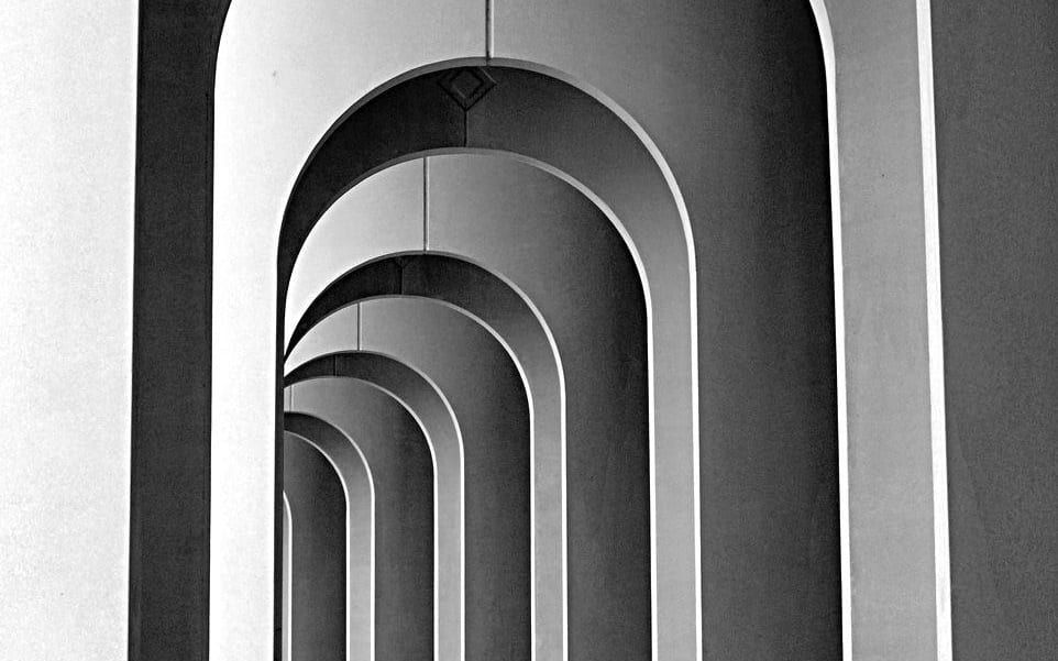 A receding colonnade of identical stone arches