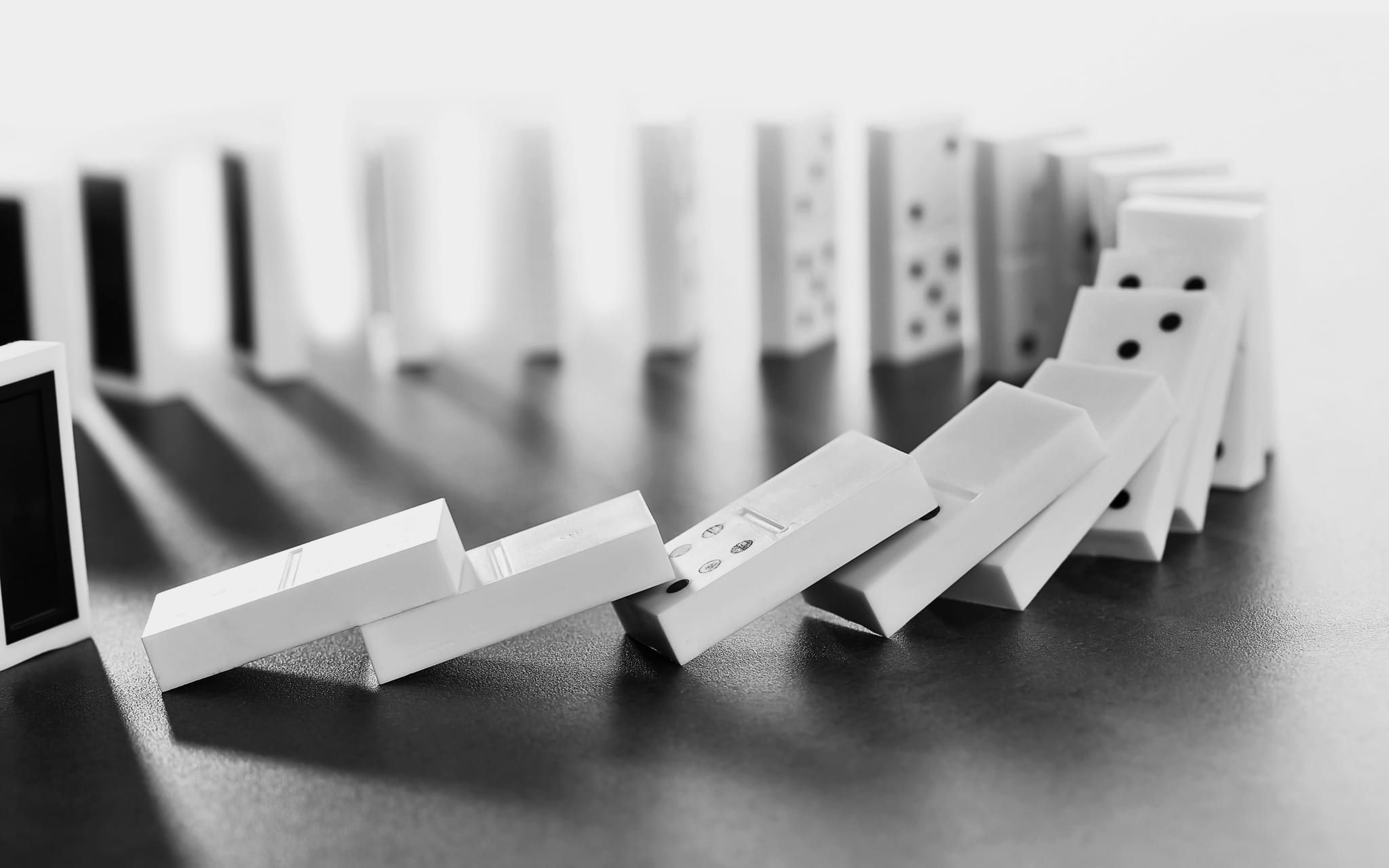 A line of tooth-shaped dominoes toppling one into the next